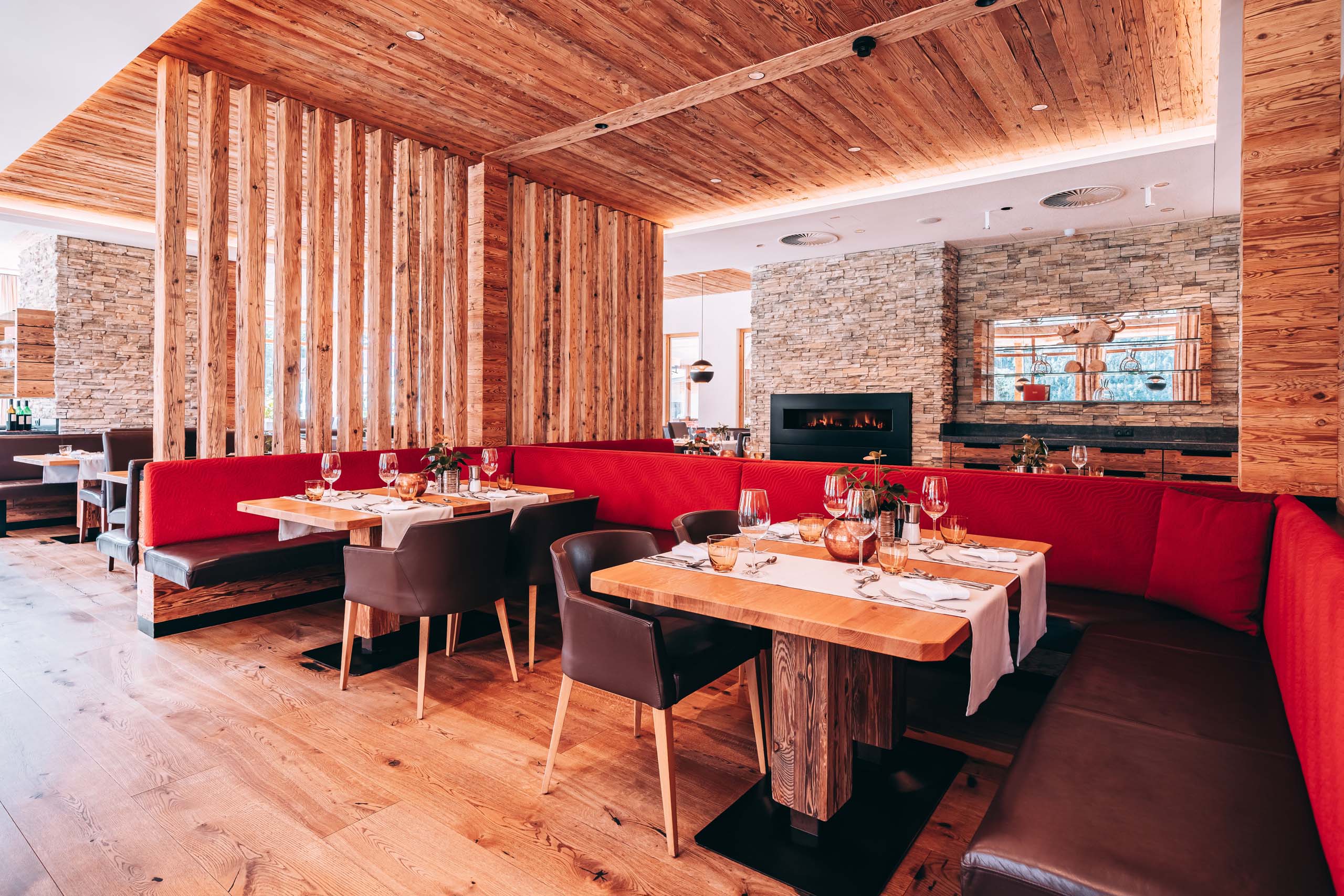 Familiennestl Seeblick II Modernes Restaurant mit Holzmöbeln und roten Sitzbänken