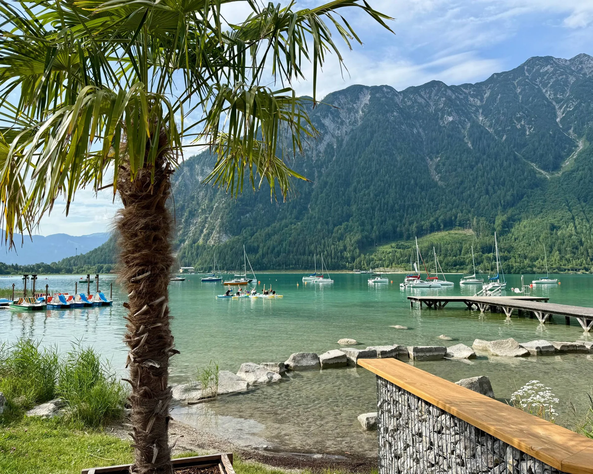 Fitness und Yoga im Hotel in Tirol Palme am See mit Segelbooten und Bergen im Hintergrund