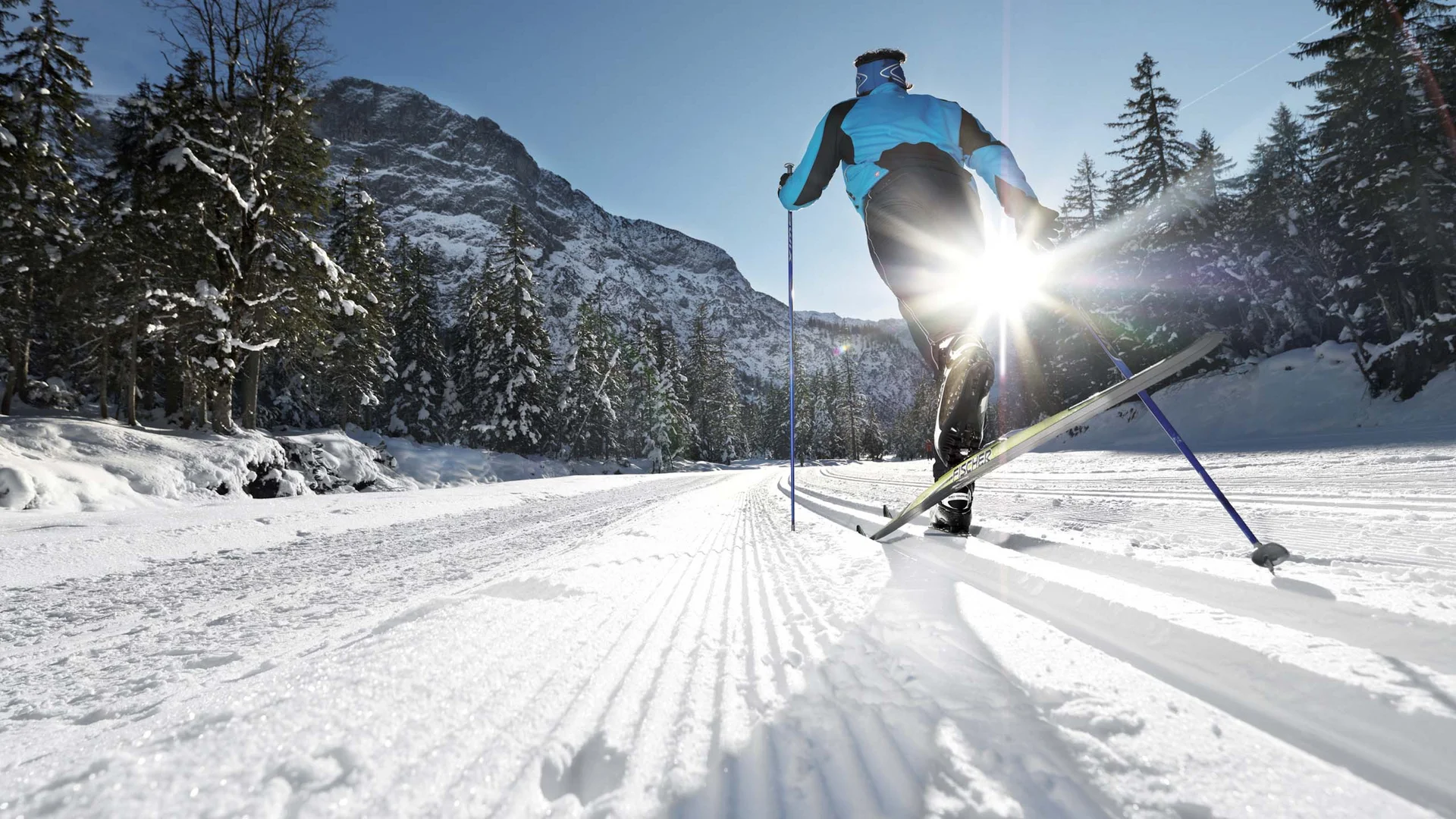 Willkommen im Familienhotel Buchau am Achensee Langläufer bei Sonnenschein in verschneiter Berglandschaft