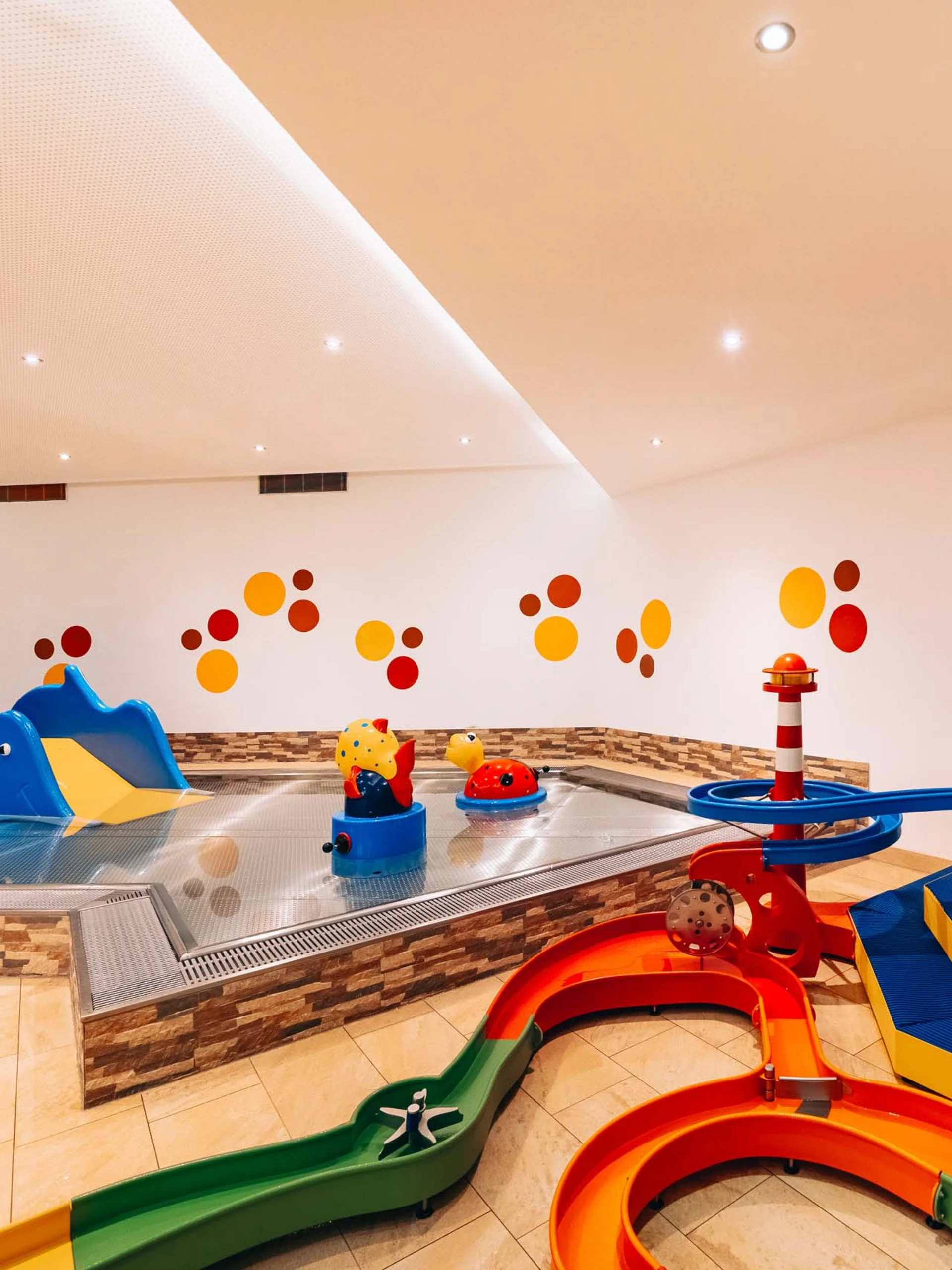 Wir lassen Bilder sprechen. Buntes Indoor-Kinderbecken mit Rutschen und Wasserspielzeug