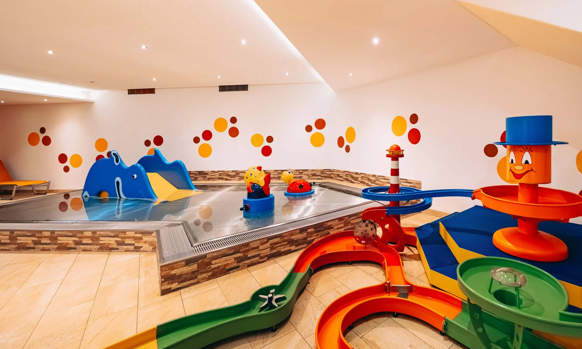 Wasserspaß im Familienhotel in Tirol mit Pool Buntes Indoor-Kinderbecken mit Rutschen und Wasserspielzeug