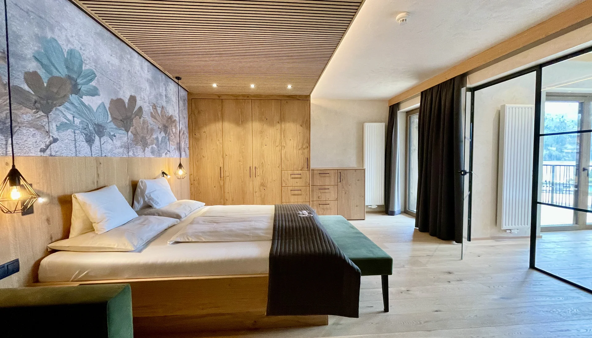 Stammgast werden und Buchau-Taler sammeln Modernes Schlafzimmer mit Holzmöbeln, großem Bett und Zugang zum Balkon