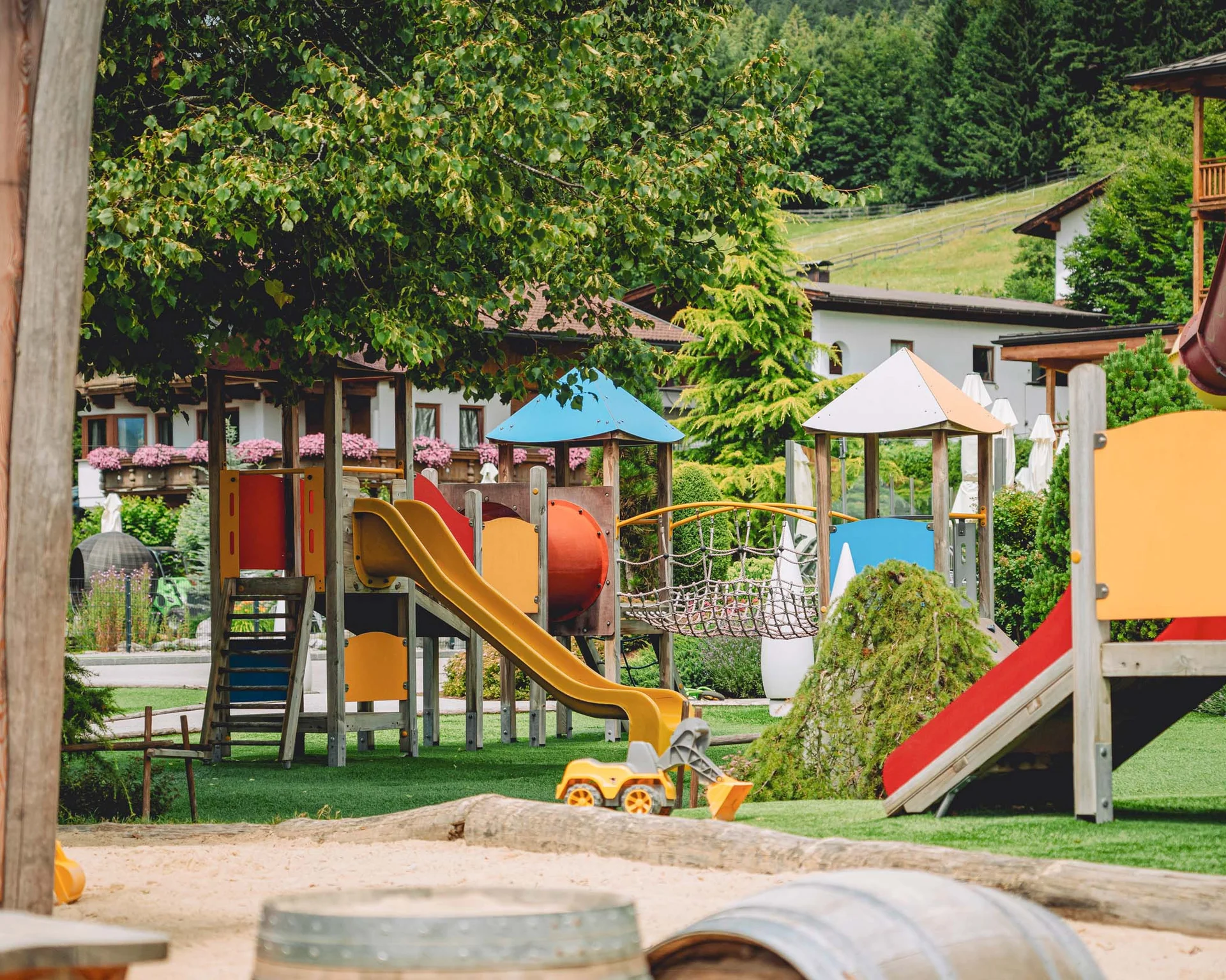 Familienurlaub mit Baby und Kleinkind im Buchau Kinderspielplatz mit Rutschen, Spielgeräten und Sandkasten in einem Garten