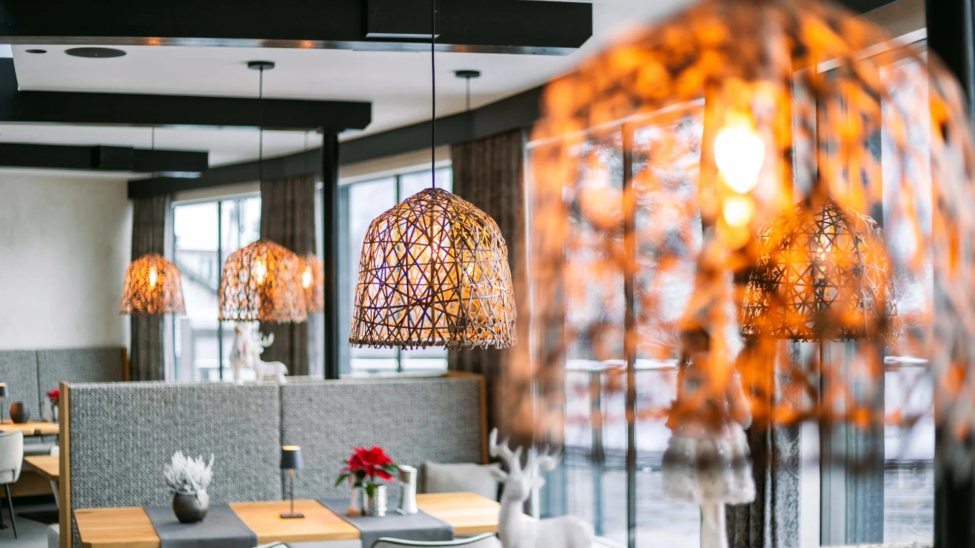 Willkommen im Familienhotel Buchau am Achensee Gemütliches Restaurant mit warmen Lampen und winterlicher Dekoration