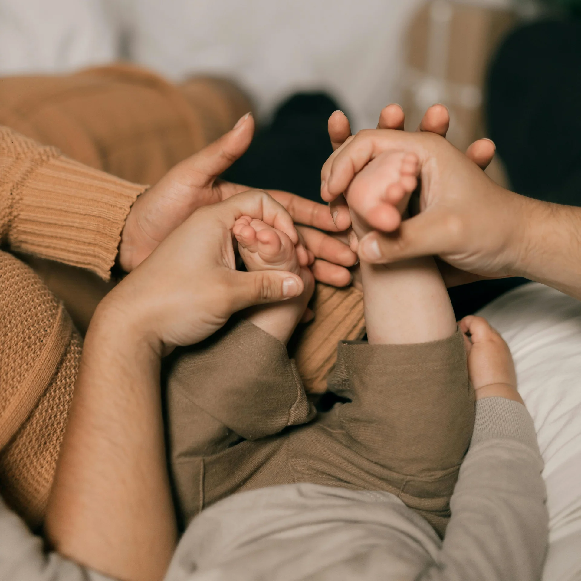 Familienzeit im Kinderhotel Buchau am Achensee Eltern halten und massieren die Füße eines Babys