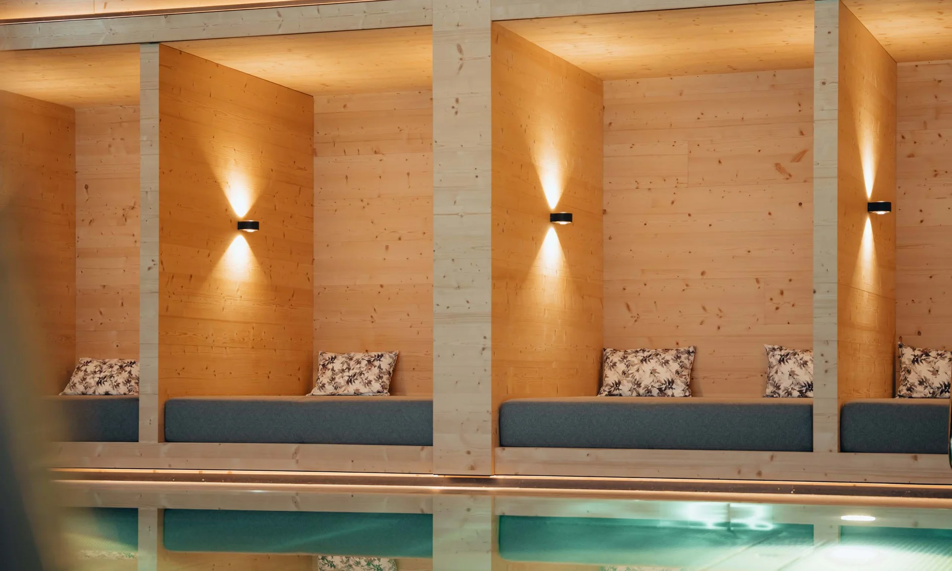 Wir lassen Bilder sprechen. Holzvertäfelte Lounge mit gepolsterten Bänken und sanfter Wandbeleuchtung