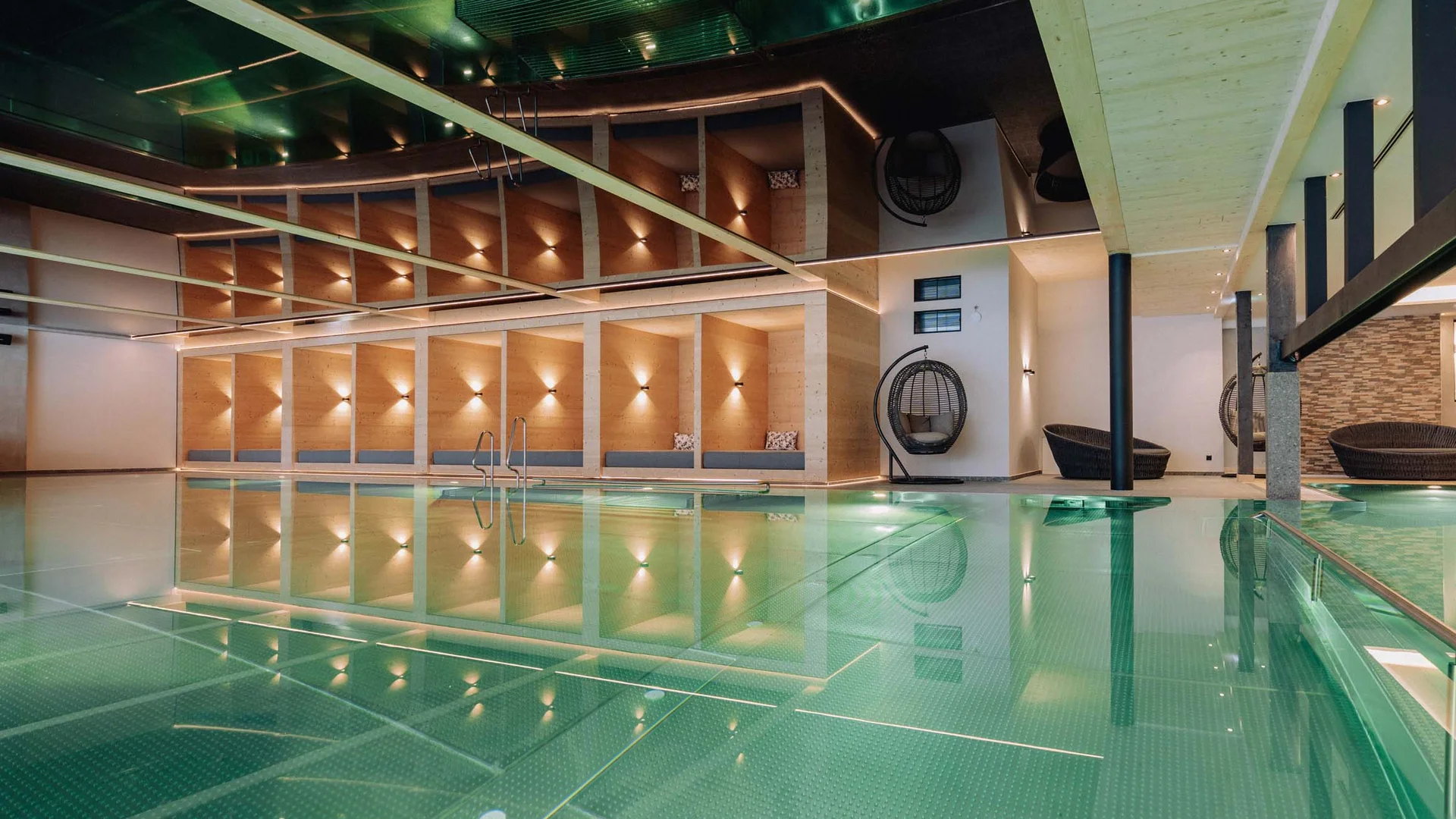 Wasserspaß im Familienhotel in Tirol mit Pool Modernes Hallenbad mit Holzdekor und Sitzbereichen neben dem Pool