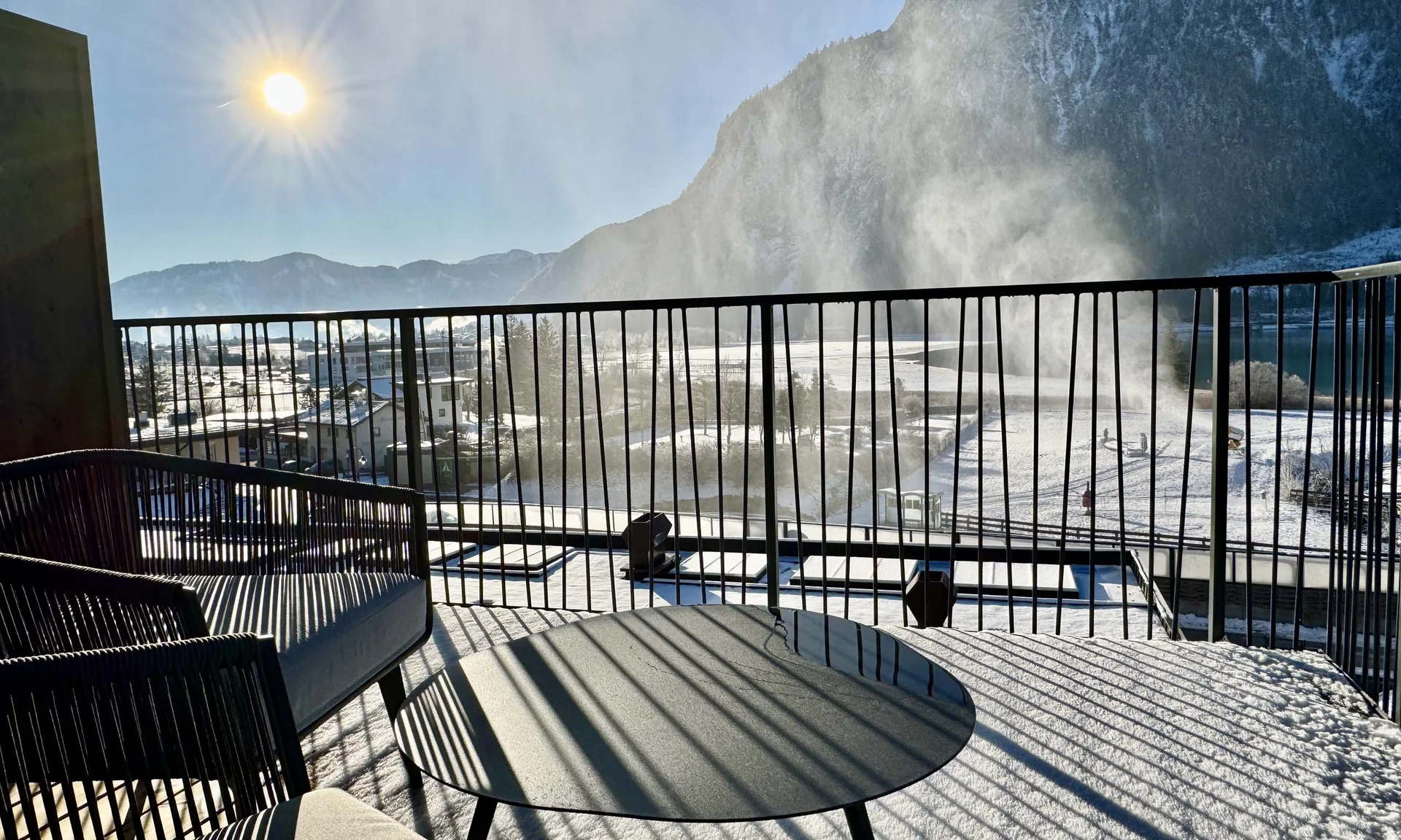 Wir lassen Bilder sprechen. Sonniger verschneiter Balkon mit Bergblick und Nebel am Morgen