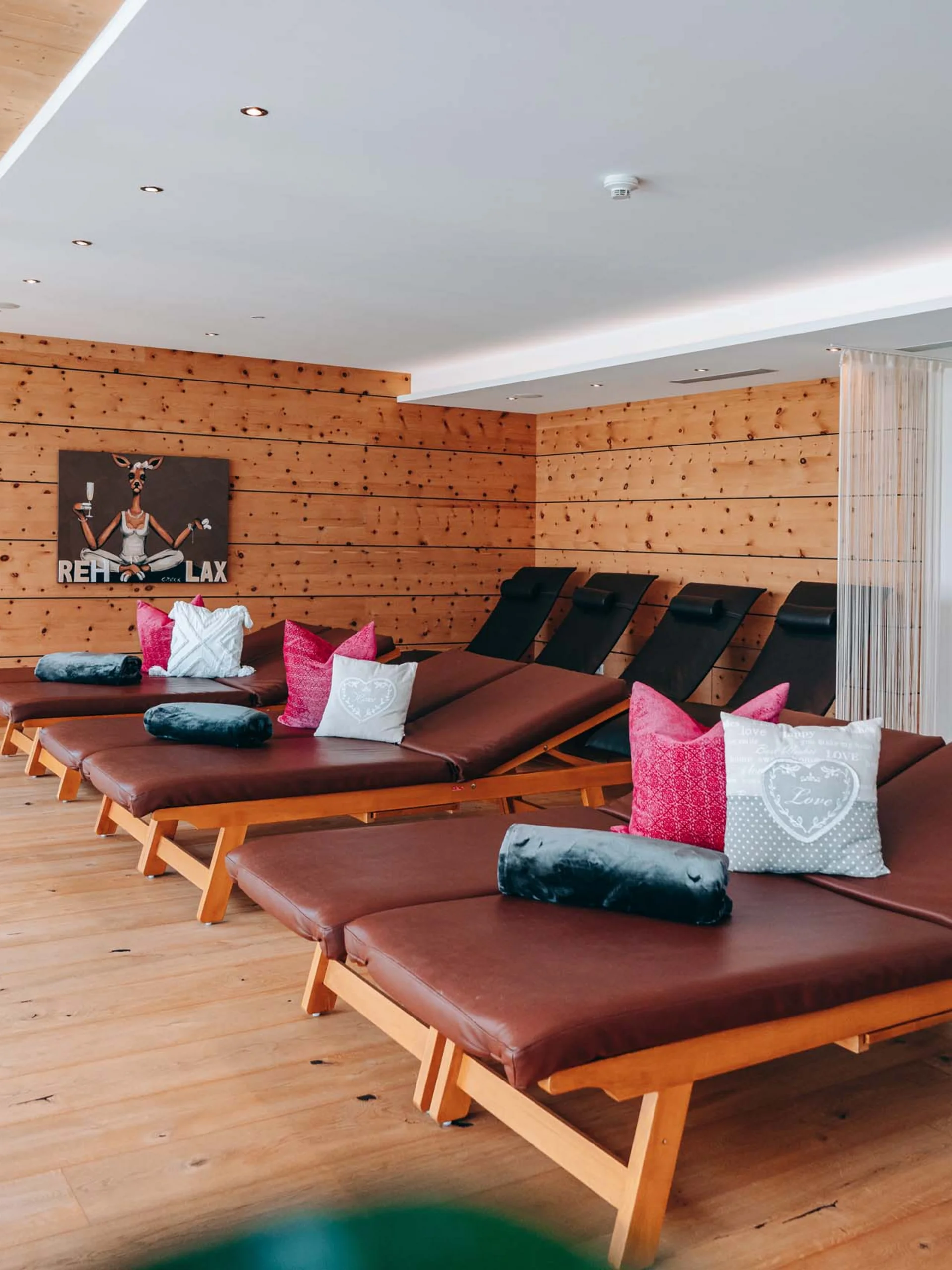 Wir lassen Bilder sprechen. Ruheraum mit Liegen, Holzboden und Holzwänden in einer entspannten Atmosphäre