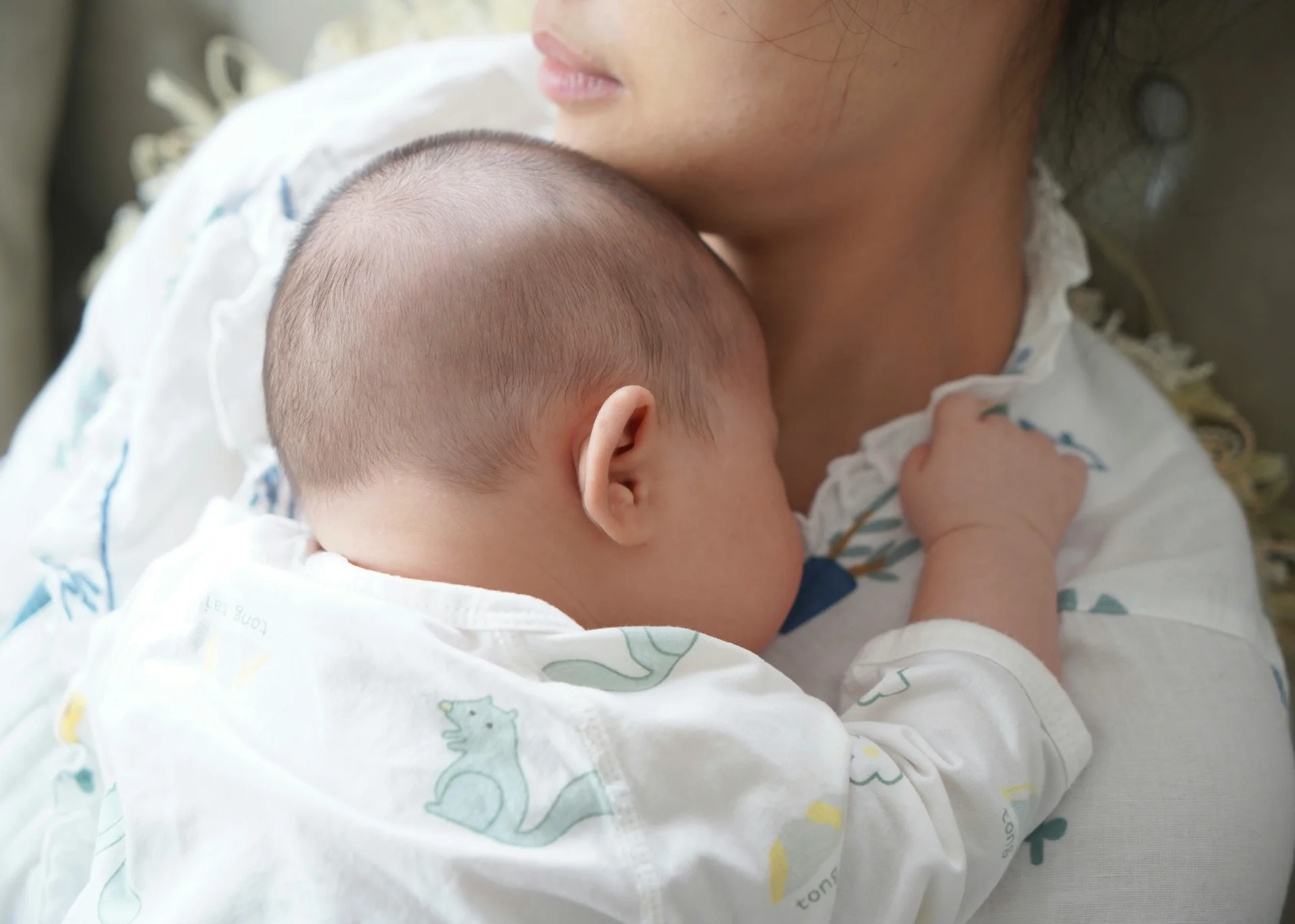 Familienurlaub mit Baby und Kleinkind im Buchau Baby schläft an der Schulter der Mutter