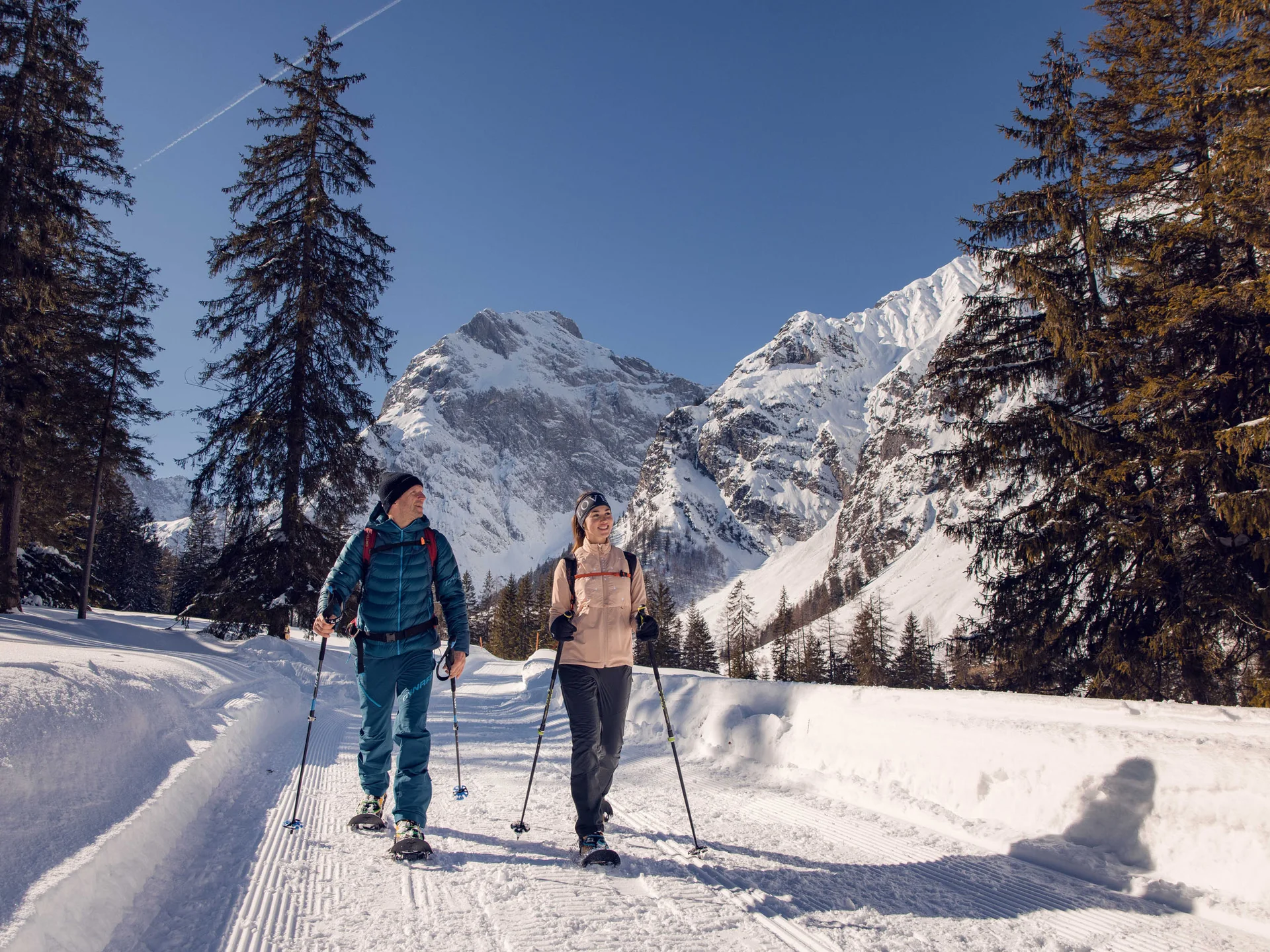 Erholungsurlaub für Eltern Zwei Personen beim Schneeschuhwandern in verschneiter Berglandschaft