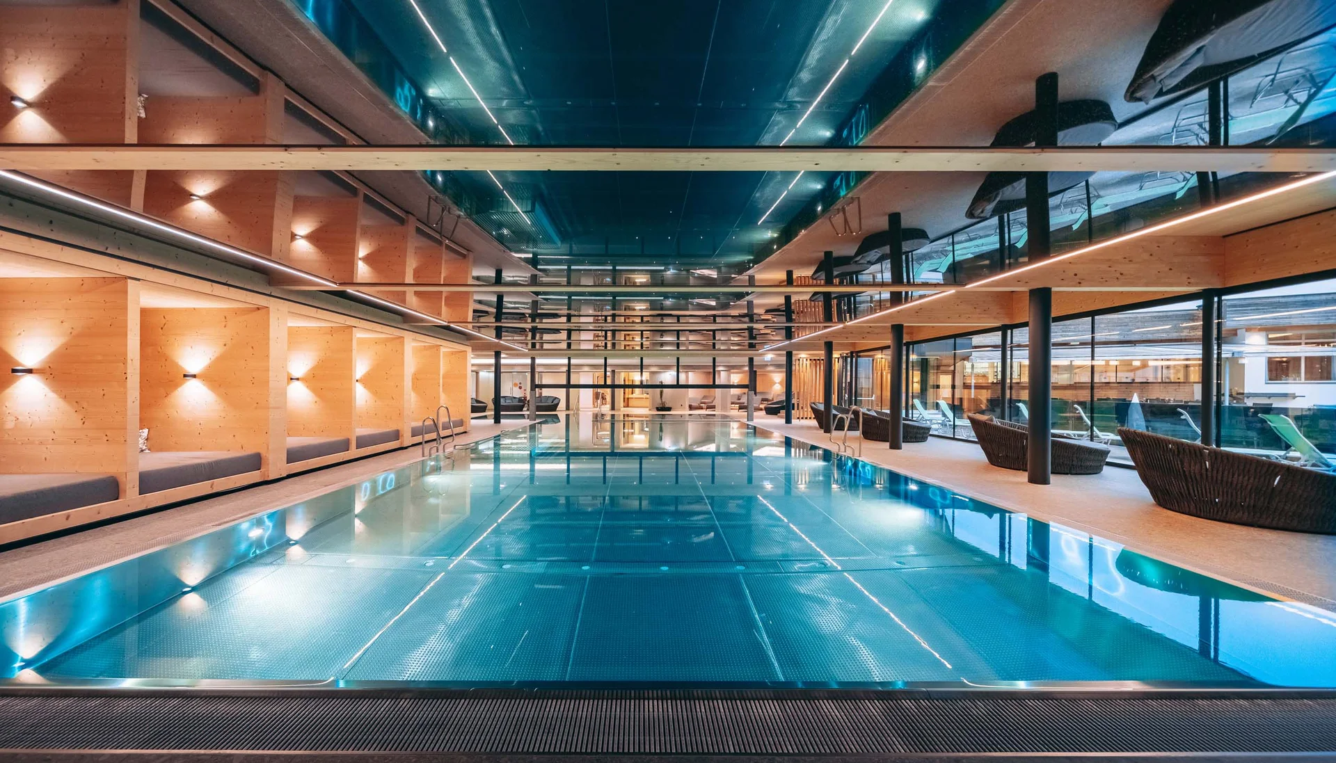 Urlaub im Familienresort in Österreich Moderner Innen-Schwimmbad mit Liegebereichen und Holzwänden