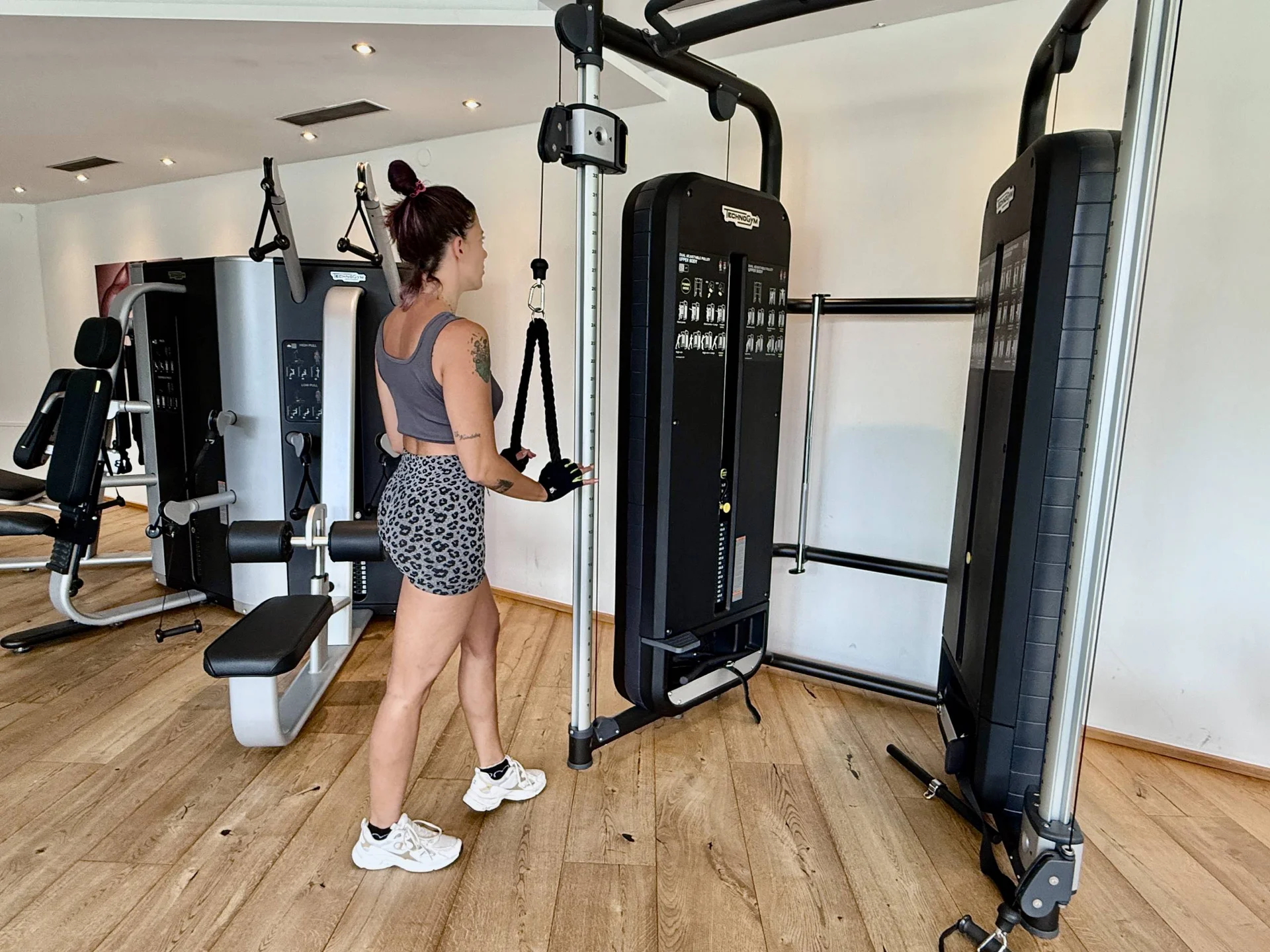 Fitness und Yoga im Hotel in Tirol Frau trainiert an Kabelzugmaschine im Fitnessstudio