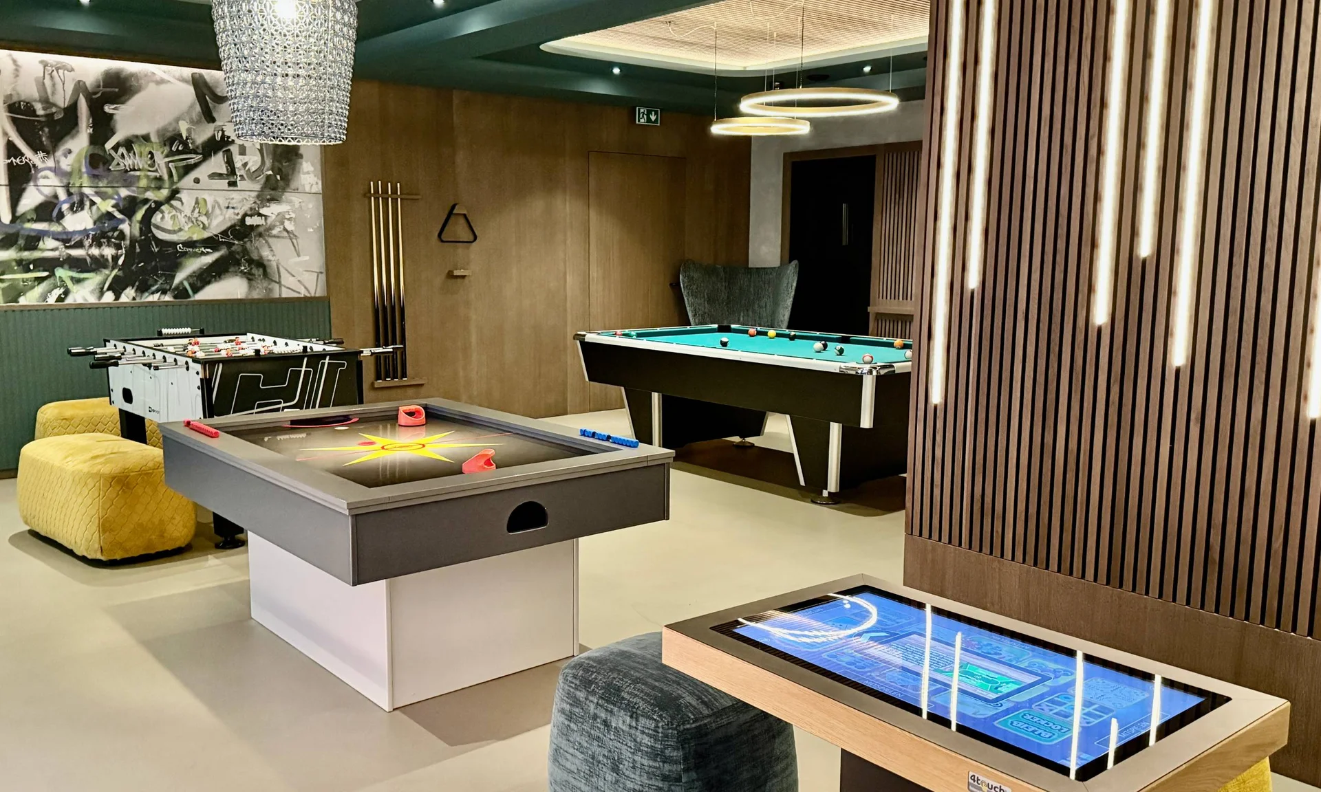 Wir lassen Bilder sprechen. Moderner Spieleraum mit Airhockey-, Kicker- und Billardtisch sowie digitalem Spieltisch