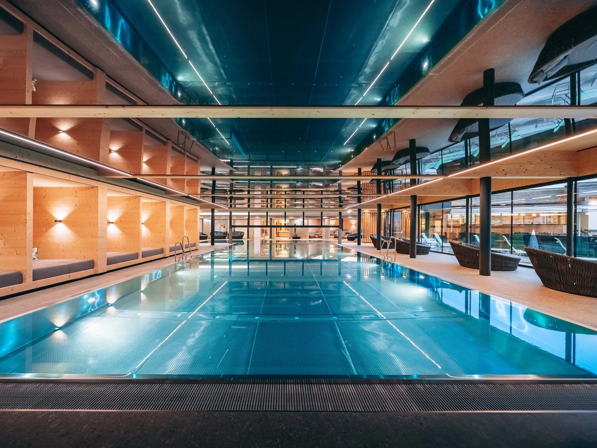 Wasserspaß im Familienhotel in Tirol mit Pool Moderner Innenpool mit Holzwänden und Liegestühlen