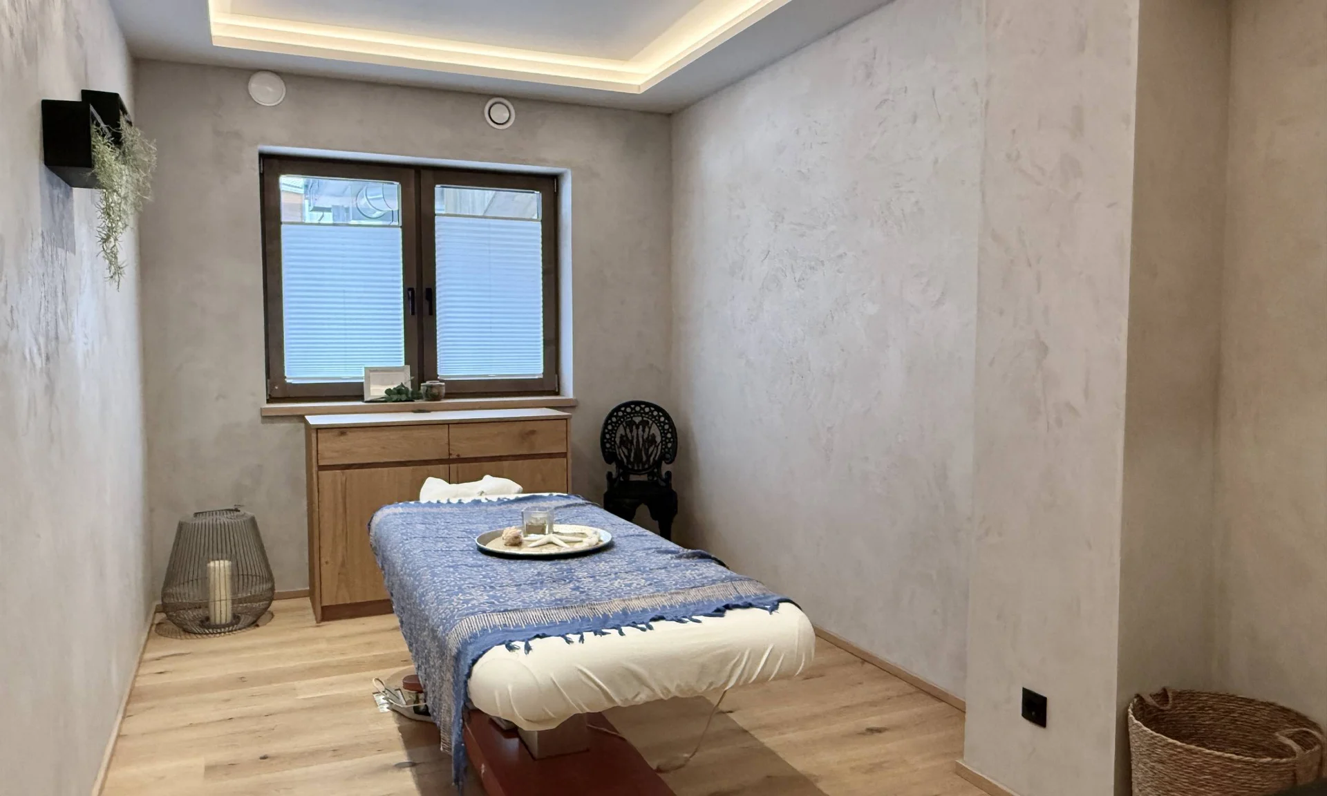 Die Wohlfühlbehandlungen am Achensee Sanfter Massageraum mit Behandlungsbett, Holzmöbeln und entspannender Dekoration