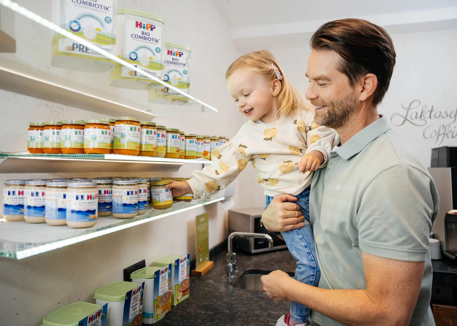 Ihr Hotel mit Kinderbetreuung in Tirol Mann hält Kind beim Auswählen von Babynahrung im Regal