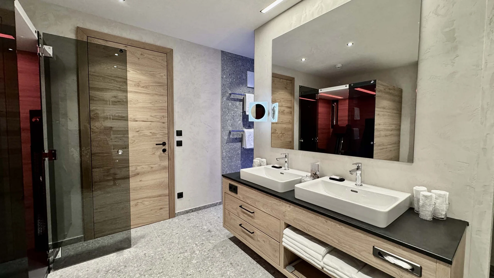 Zimmer und Angebote am Achensee Moderne Badezimmer mit Holz- und Steindetails, Doppelwaschbecken und großen Spiegel