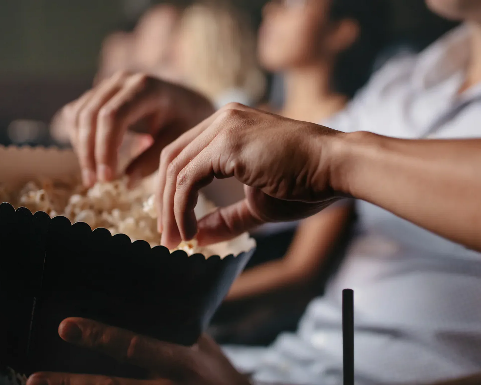 Urlaub im Hotel mit Indoorspielplatz Person nimmt Popcorn aus einer großen Schüssel im Kino