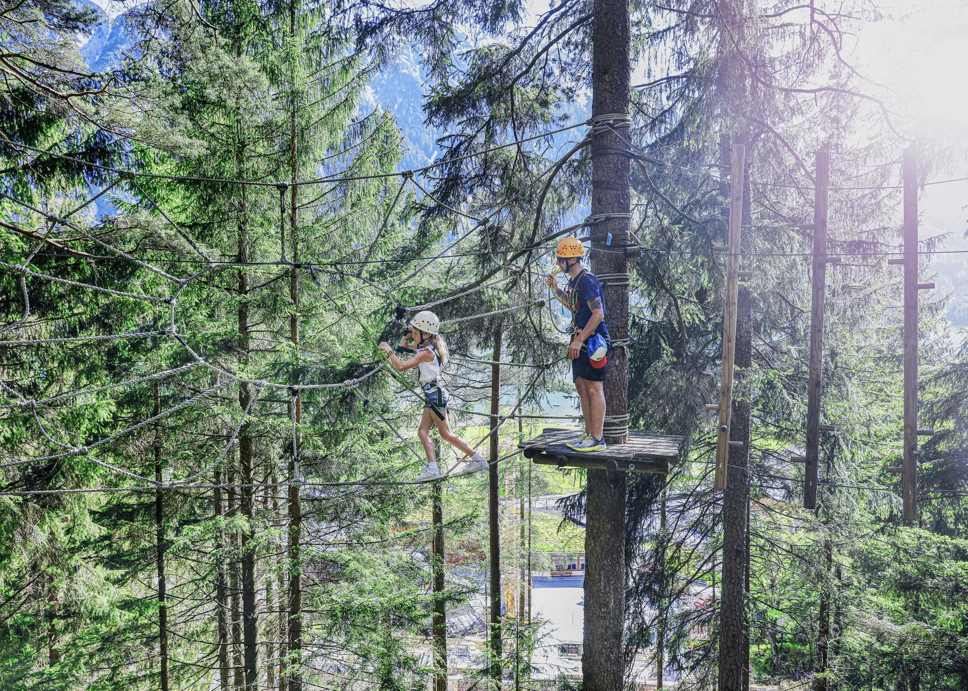 Action im Hotel mit Kletterhalle Kind und Erwachsener beim Klettern in Hochseilgarten im Wald