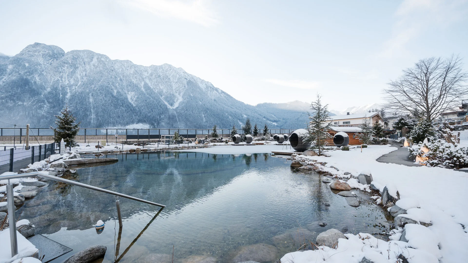 Wasserspaß im Familienhotel in Tirol mit Pool Bergsee im Winter mit schneebedecktem Ufer und Bergen im Hintergrund