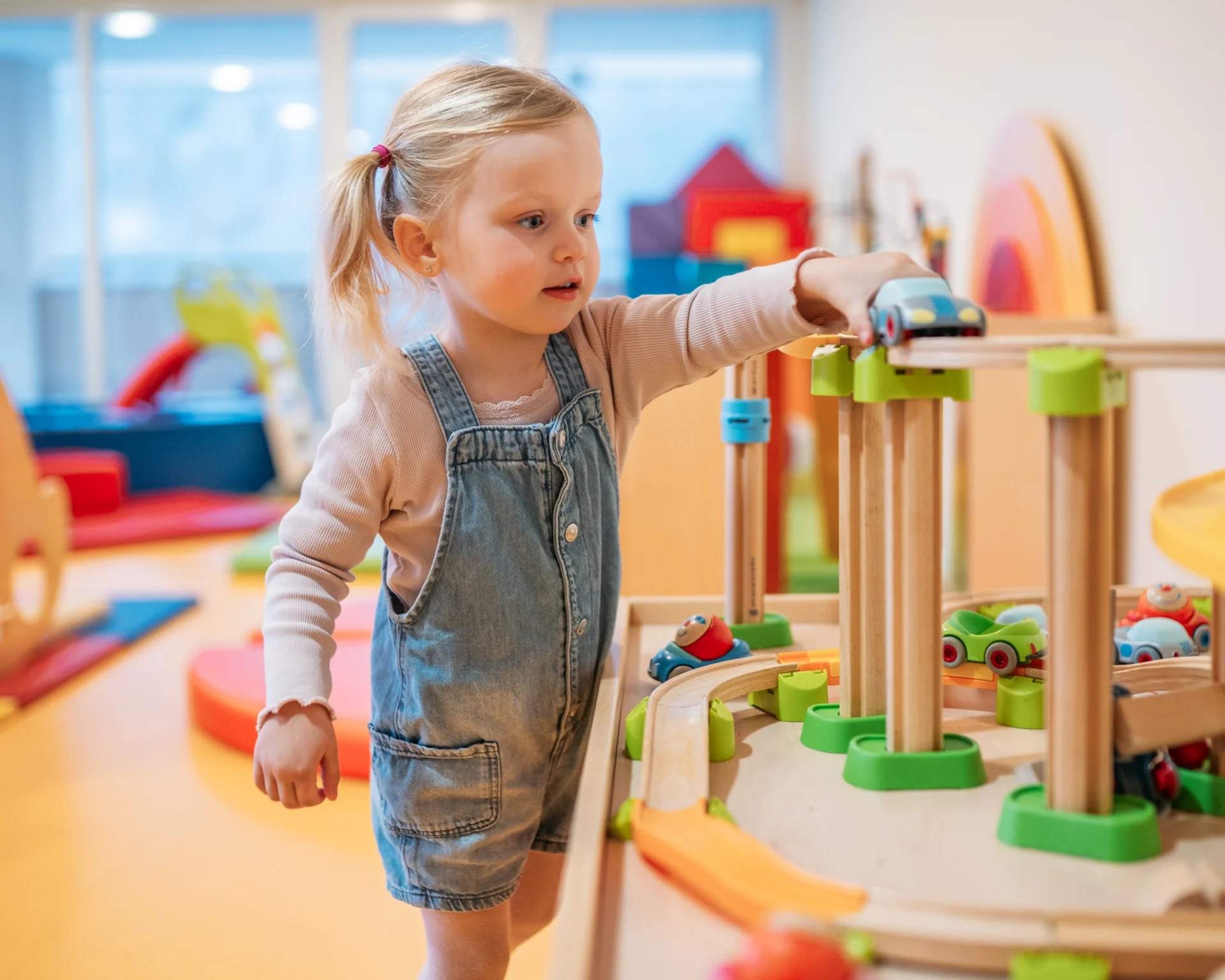 Die besten Angebote am Achensee für Sie Kleines Mädchen spielt mit einer Holzeisenbahn im Spielzimmer