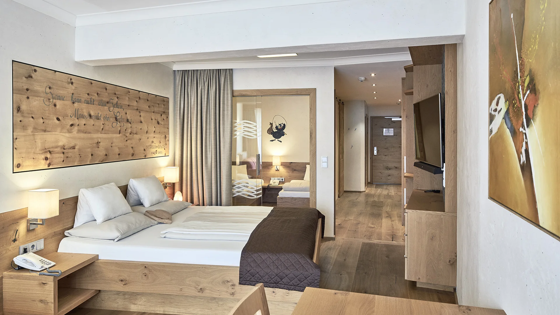 Zimmer und Angebote am Achensee Modernes Hotelzimmer mit Holzmöbeln, Doppelbett und Flur zum Eingang