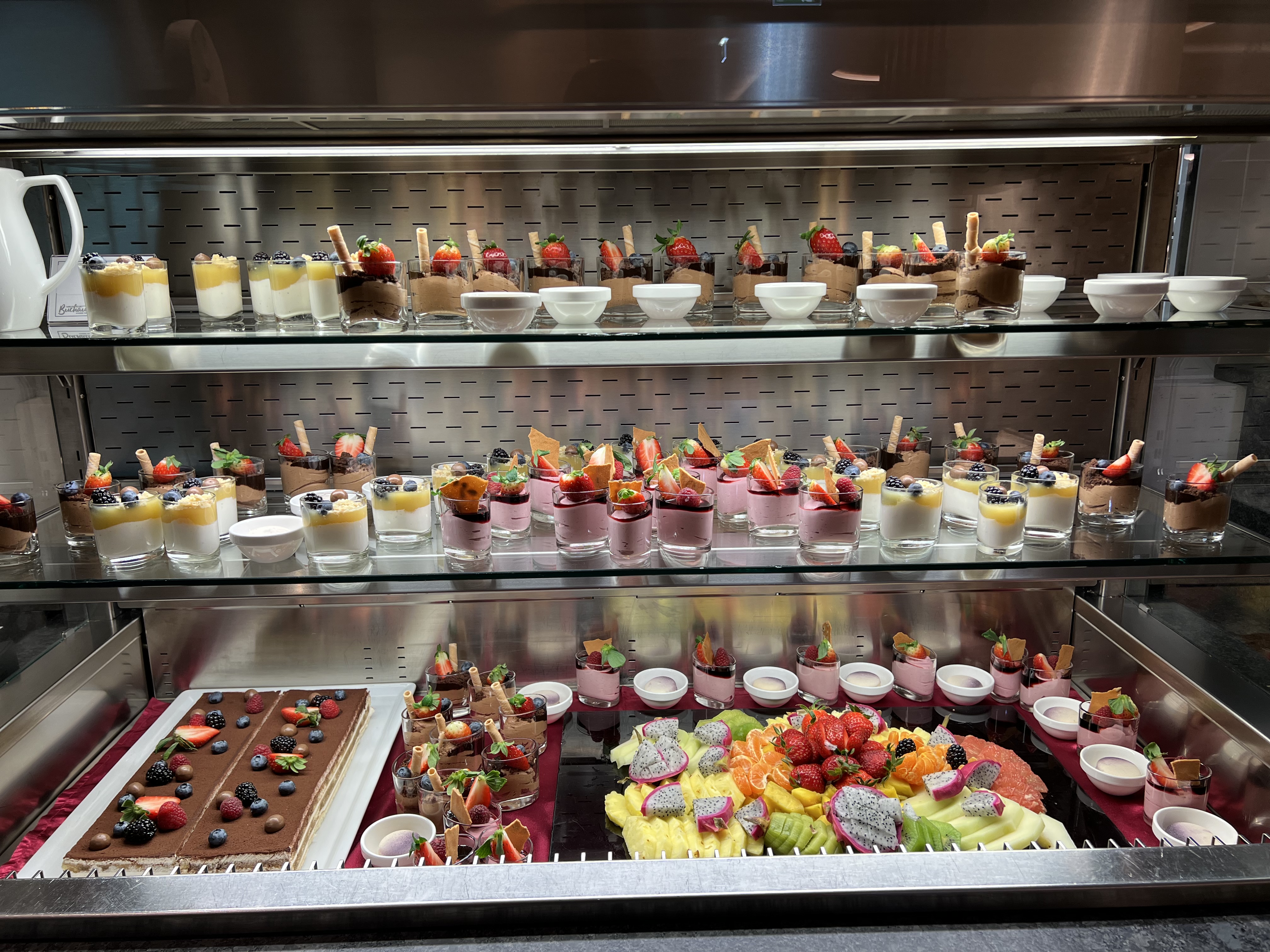 Wir lassen Bilder sprechen. Glasdesserts und Obstarrangement in einem gekühlten Display