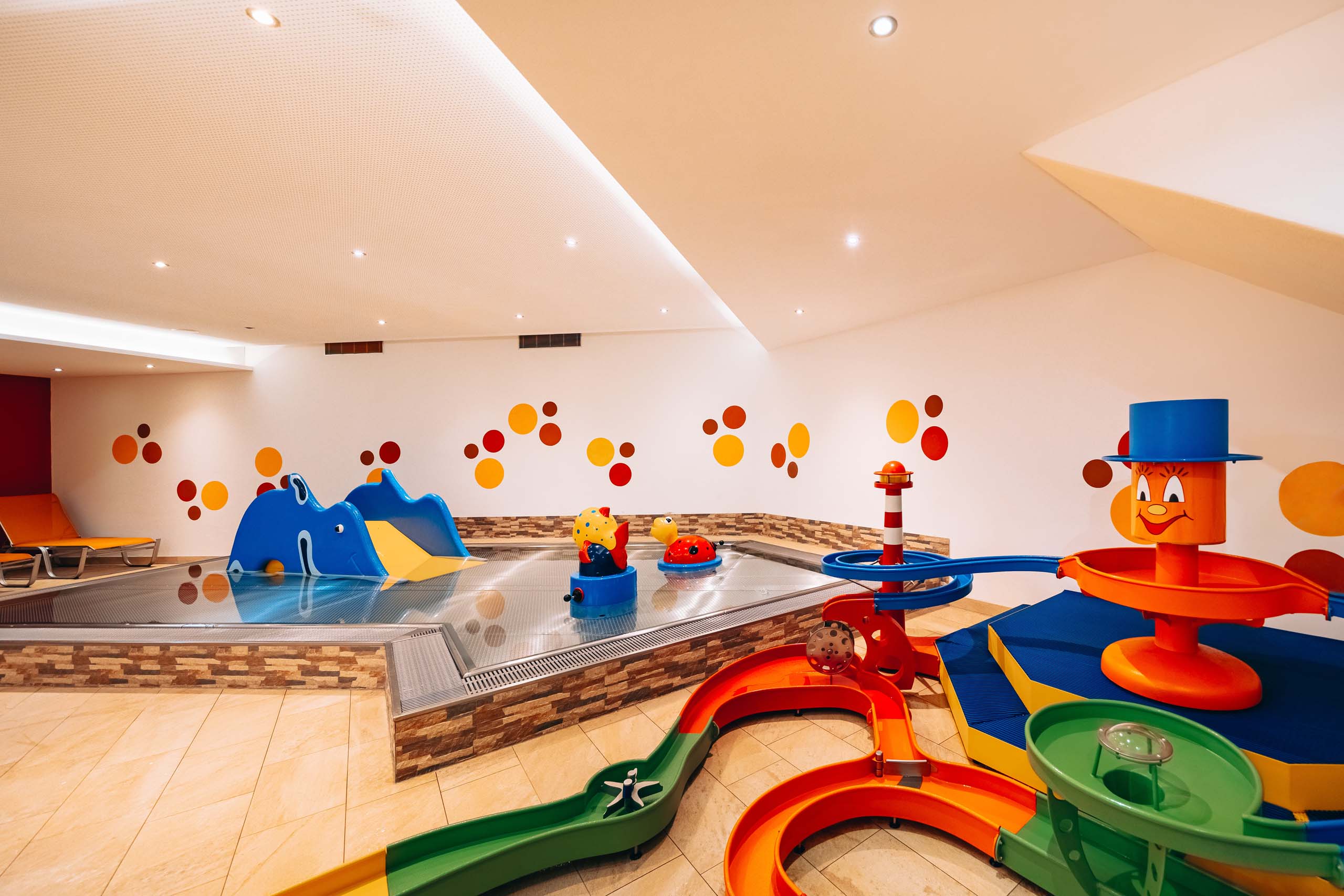 Wir lassen Bilder sprechen. Buntes Indoor-Kinderbecken mit Rutschen und Wasserspielzeug