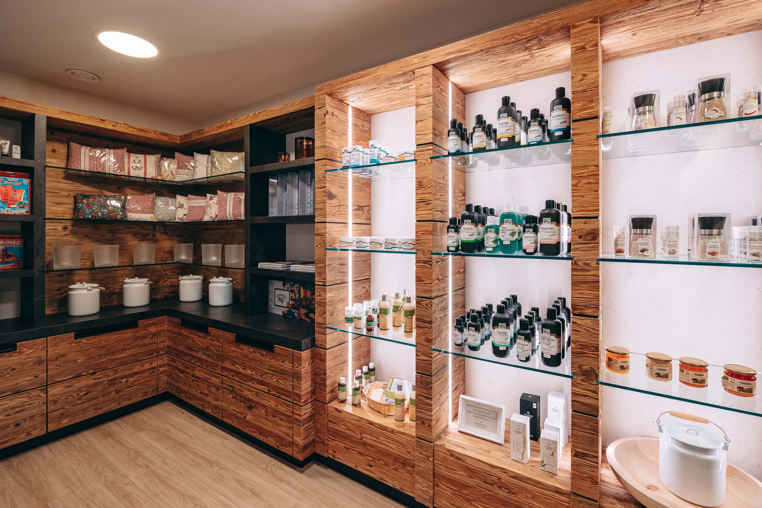 Wir lassen Bilder sprechen. Regale mit Kosmetik und Salzprodukten in einem hellen Ladengeschäft mit Holzverkleidung