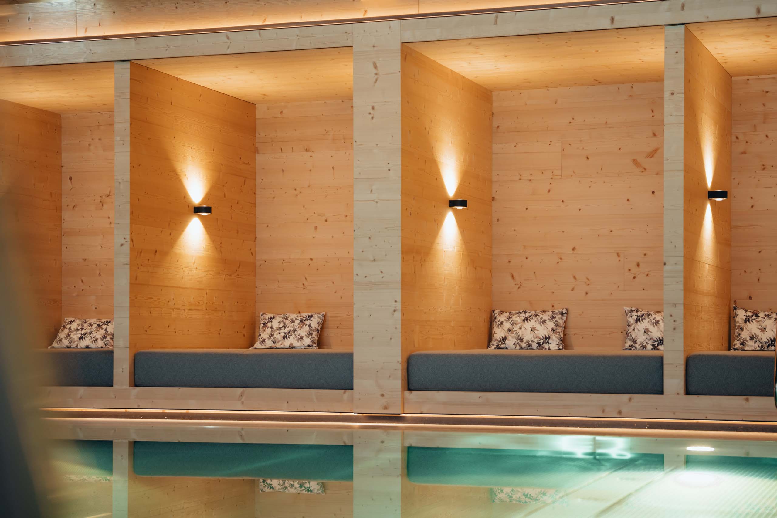 Wir lassen Bilder sprechen. Holzvertäfelte Lounge mit gepolsterten Bänken und sanfter Wandbeleuchtung