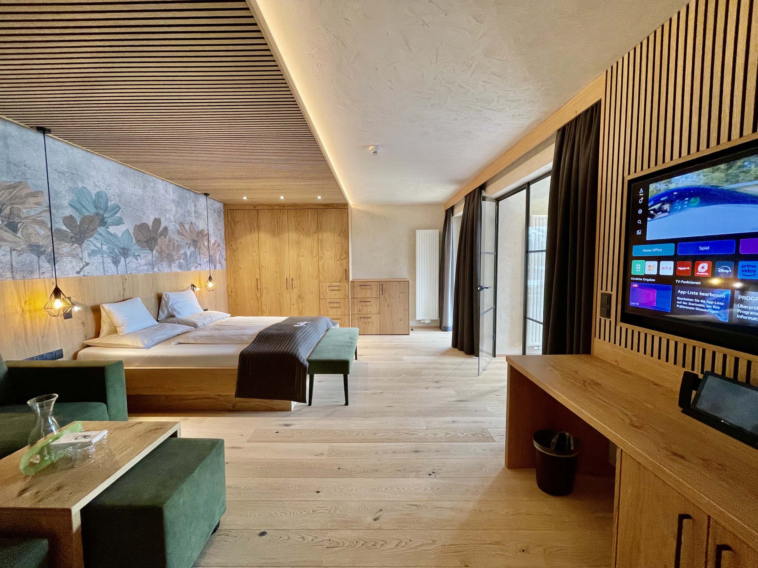 Wir lassen Bilder sprechen. Modernes Hotelzimmer mit Doppelbett, Holzdecke und TV