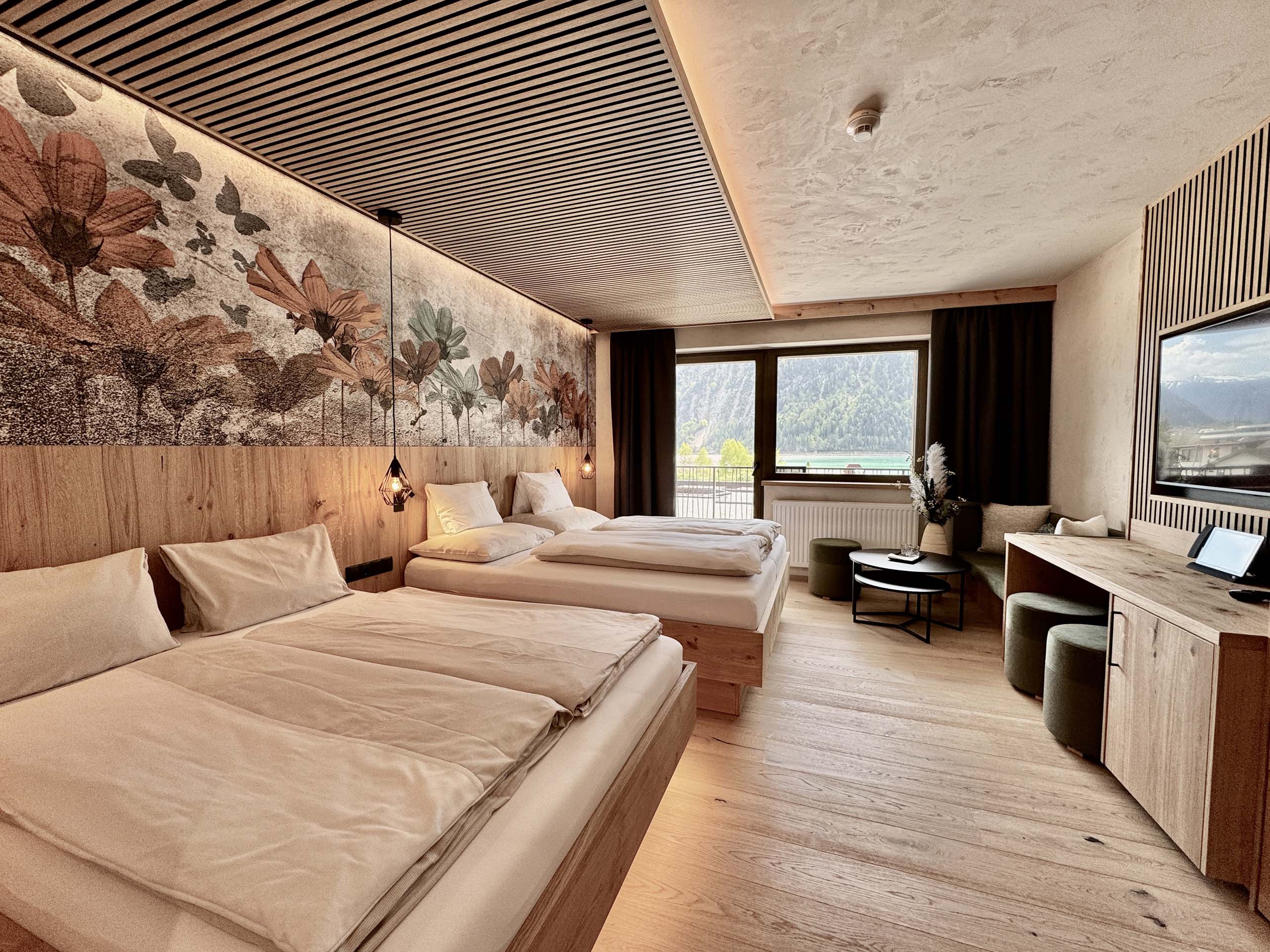 Wir lassen Bilder sprechen. Modernes Hotelzimmer mit zwei Betten und Blick auf Berge