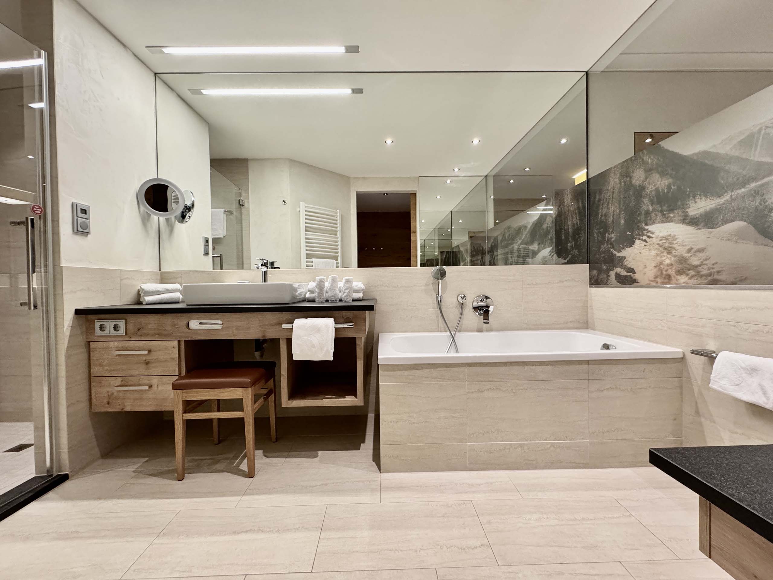 Wir lassen Bilder sprechen. Modernes Badezimmer mit Badewanne, großem Spiegel und Waschtisch aus Holz