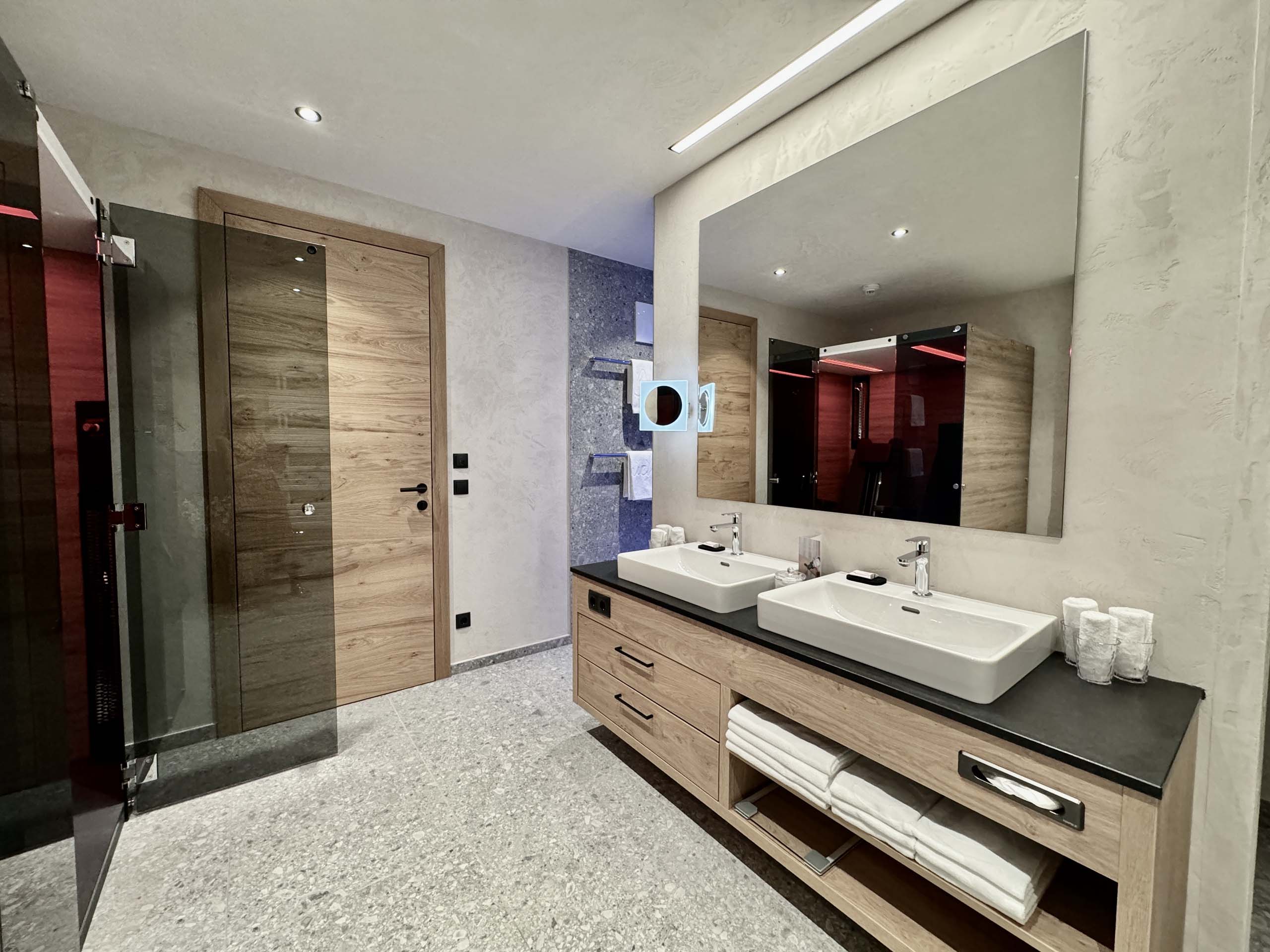 Wir lassen Bilder sprechen. Moderne Badezimmer mit Holz- und Steindetails, Doppelwaschbecken und großen Spiegel