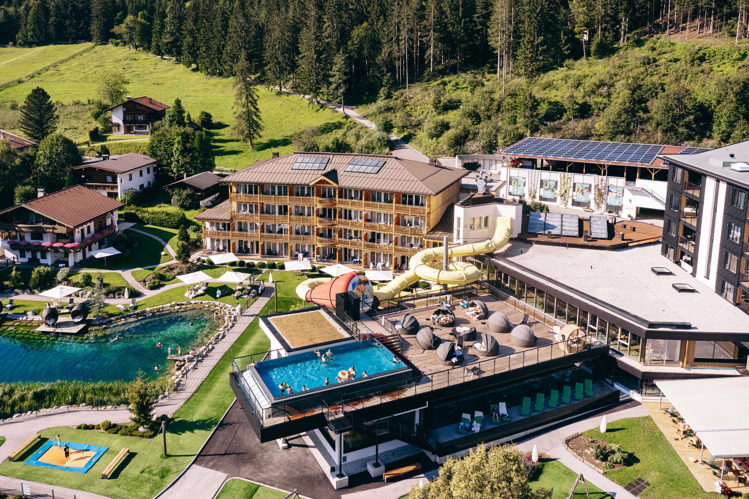 Wir lassen Bilder sprechen. Hotelanlage mit Schwimmbad, Wasserrutsche und Sauna im Waldgebiet