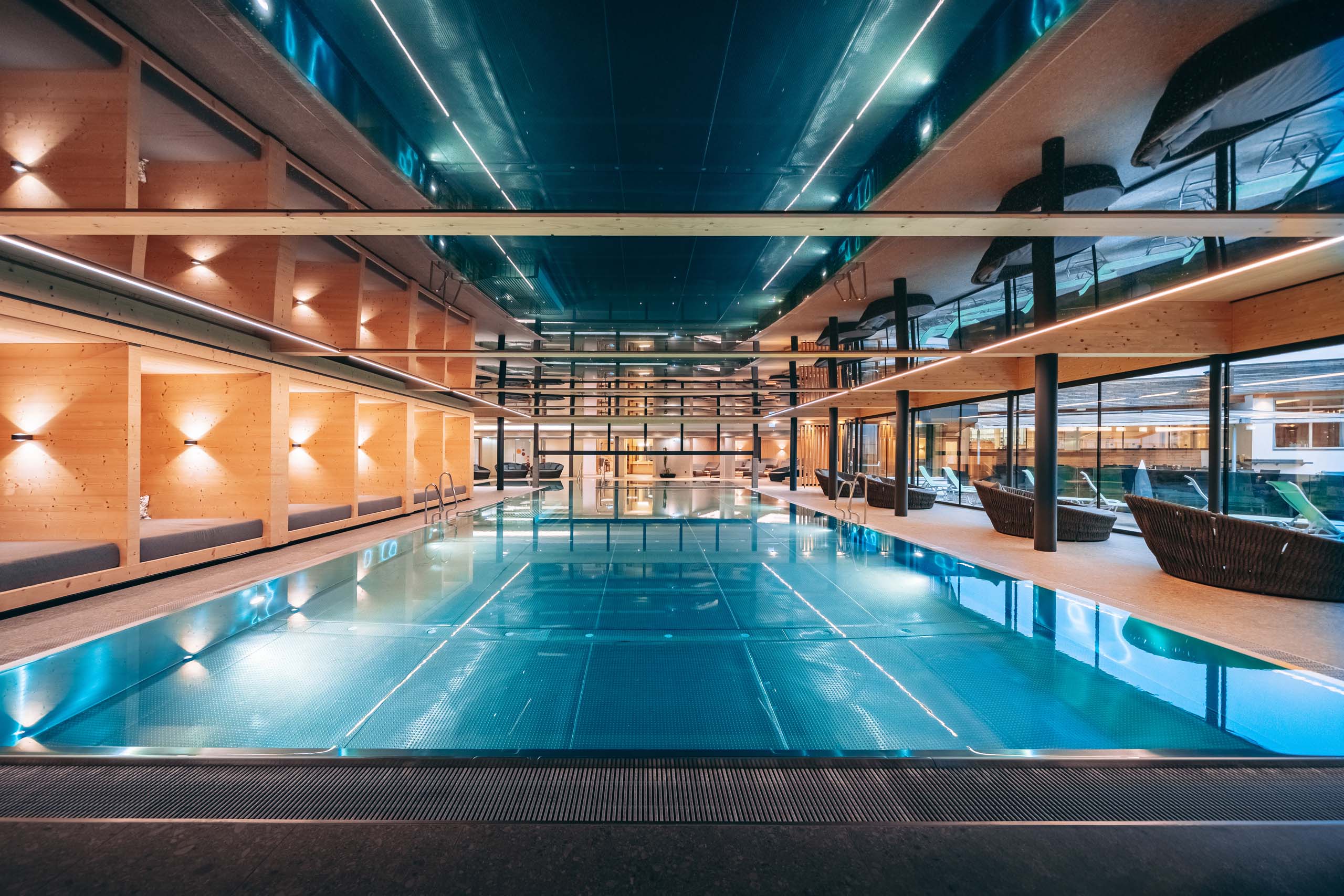 Wir lassen Bilder sprechen. Moderner Innenpool mit Holzvertäfelung und Sitzbereichen